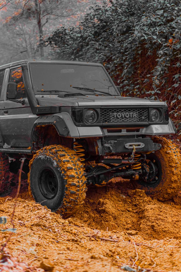 Experience a thrilling off-road journey with a rugged Toyota Land Cruiser navigating a muddy trail.
