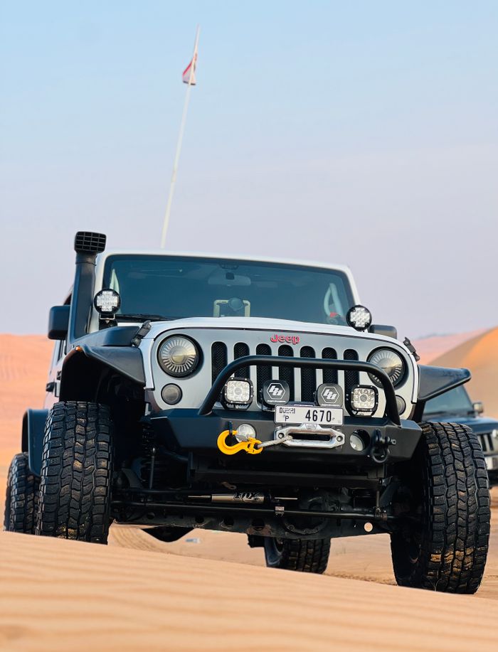 Bold off-road vehicle navigating the Sharjah desert, UAE, showcasing power and adventure.